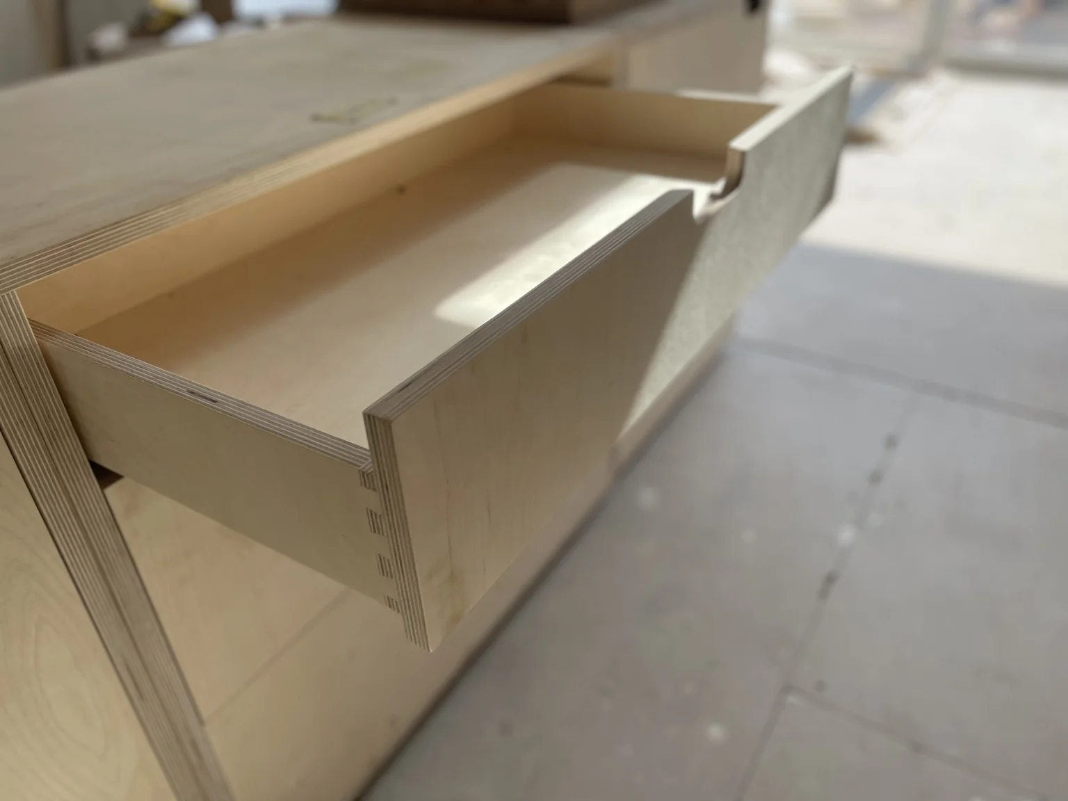 Close-up of neatly cut dovetail joints in a bespoke plywood drawer at Sandy Park