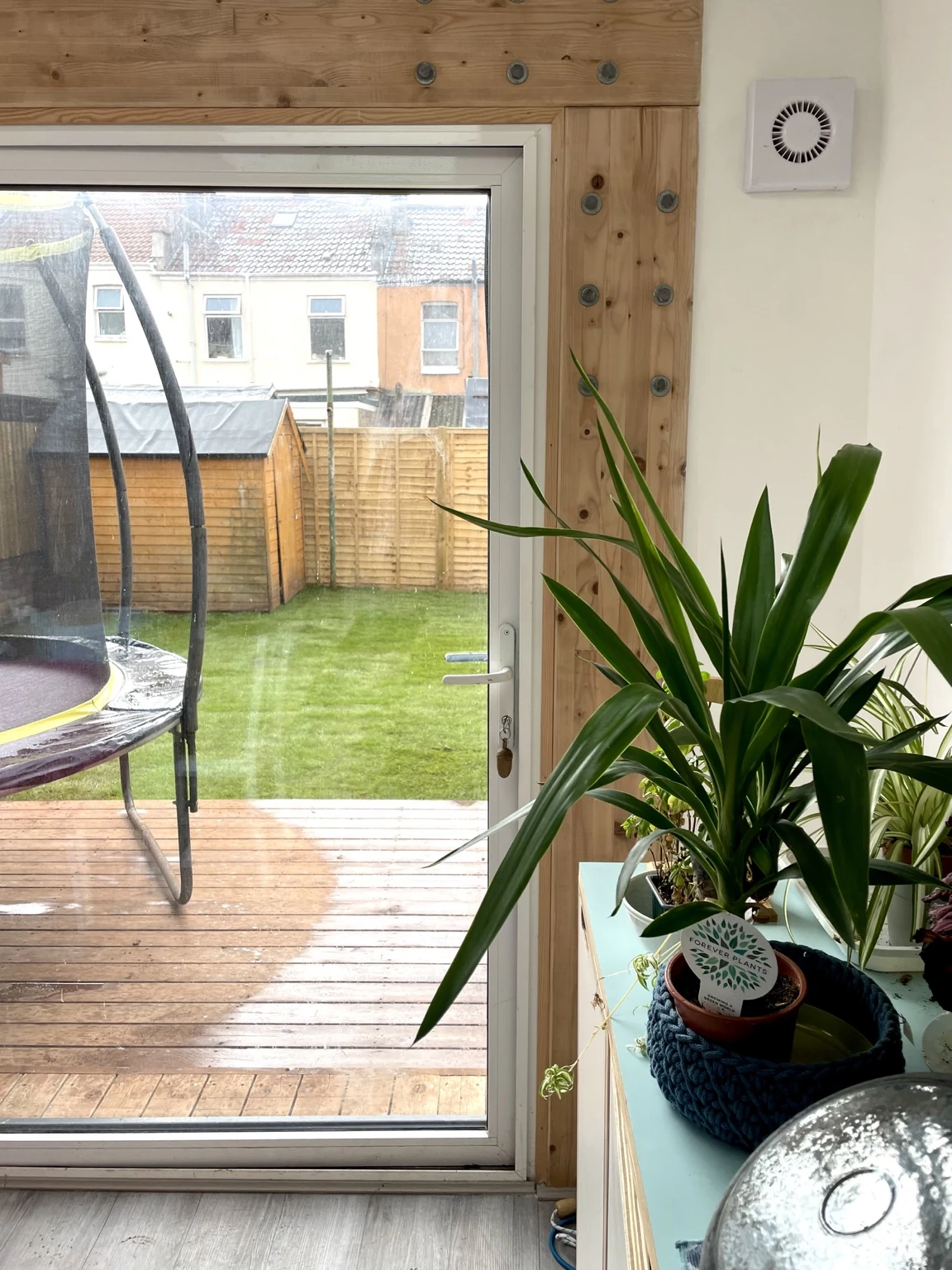 View through glazed garden doors to timber decking and rear garden at Sandy Park